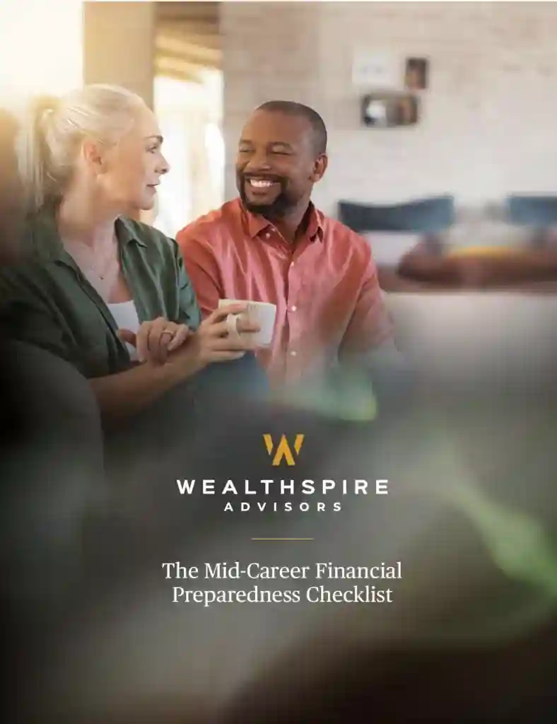 Two people drinking coffee, sitting on a couch and smiling.