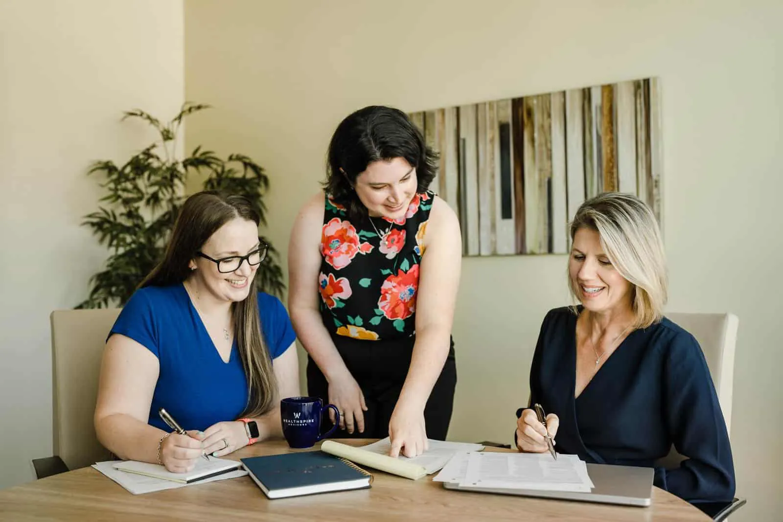 Wealthspire coworkers sitting at table looking over paperwork